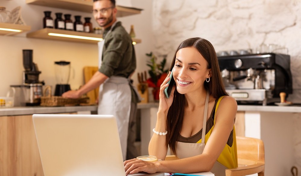 Wife receiving calls from clients while sitting at the laptop